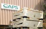 A photograph of a stack of 'Container and Pooling Solutions' boxes in front of the company logo